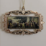Decorative ornament with a miniature mural painting of a group of Founding Fathers in a gold-colored frame, hanging on a white wall.